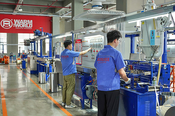 工人在操作電伴熱帶護套擠出設備。 環(huán)瑞電熱供圖